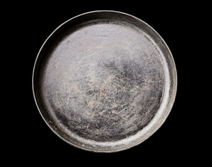 Old black cast iron Frying pan isolated on black background top view close-up