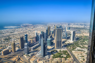 Fototapeta na wymiar Dubai, United Arab Emirates - September 2, 2016. Urbanistic view of Dubai territories from the top of Burj Khalifa skyscraper, tall buildings on the sunny autumn day
