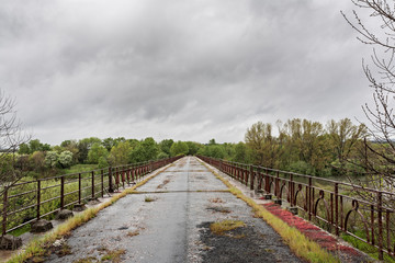 Fototapeta na wymiar A disused and aging old bridge over the Tietar river
