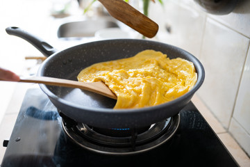 fried omelet in hot pan on strove