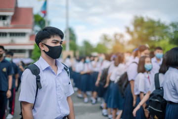 Asian male high school student in white uniform on the semester start wearing masks during the Coronavirus 2019 (Covid-19) epidemic.