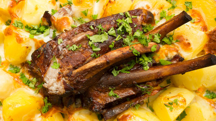 Close up on homemade marinated spicy grilled bbq ribs served on a plate with rosemary potato wedges. barbecue ribs