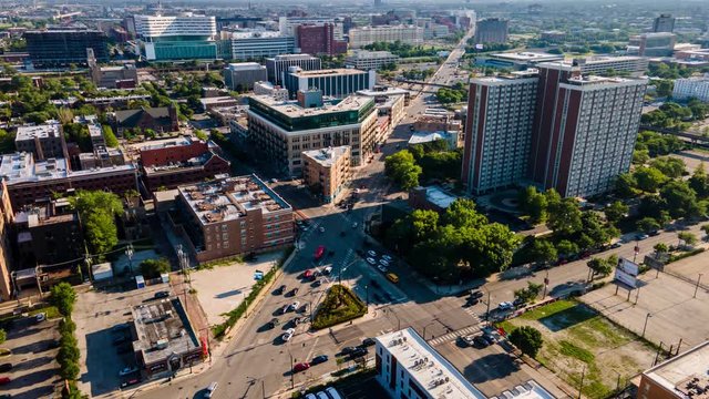 aerial drone time lapse of a local Chicago are cross walk during late afternoon with heavy traffic. commuters travel along the roads with the beautiful architecture filling the land