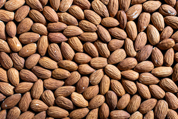 background of raw shelled nuts almonds completely filled the top view