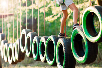 rope park. A boy passes an obstacle on tires in a rope Park.
