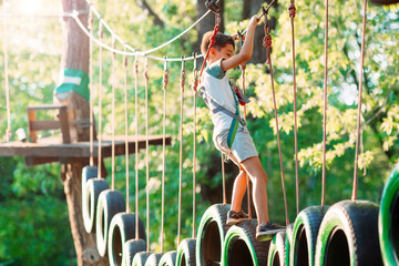 rope park. A boy passes an obstacle on tires in a rope Park. © davit85