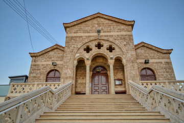 Paphos, Cyprus - July 23, 2019. Modern orthodox church built in the Romanesque style in the city of Paphos, Cyprus.  A beautiful religious temple with an arch in front of the entrance.