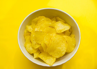 plate with chips on a yellow background top view. junk food