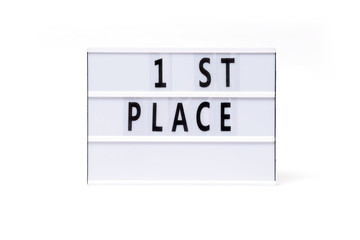 1 st place. Text on a vintage lightbox display placed on a white table on a light background. 