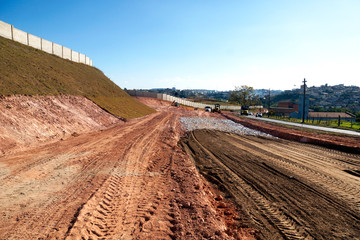 Obraz premium access road under construction, machines and vehicles do the heavy lifting