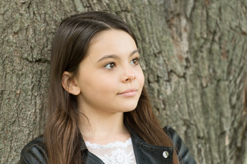 Hipster girl relaxing park tree trunk crust background, thoughtful child concept