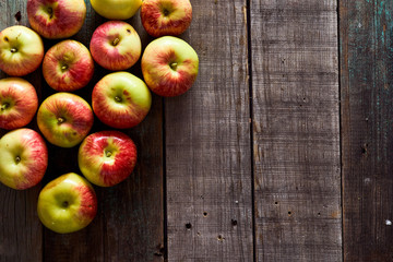 Composition of village red apples on a wooden table. With copy space.