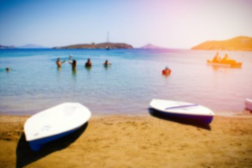 Fototapeta na wymiar People swimming, canoe cayak on the beach, summer holidays on Greek island, blurred background.