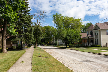 Midwest Neighborhood Street and Sidewalk with Old Homes and Green Trees during the Summer in Lemont...