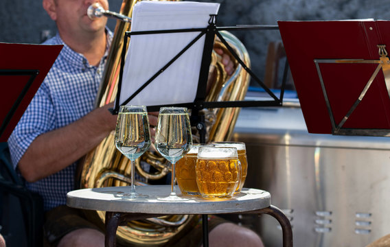 Musicisti che suonano strumenti a fiato, con boccali di birra e calici di prosecco ghiacciati. Festa della birra con banda musicale