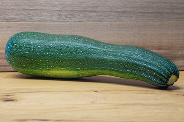 green zucchini with wooden background