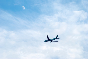 Airplane Flying Under The Moon