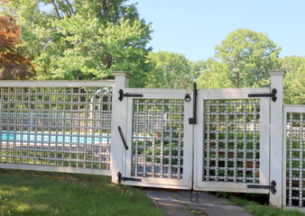 The white fence  secures the swimming pool from uninvited guests.