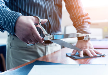 Designer tailor sew seat covers. Man use scissors for his work.
