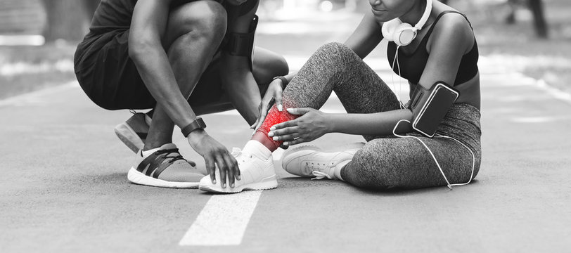 Sport Injuries. Black Girl Massaging Sprained Ankle, Suffering From Trauma During Jogging