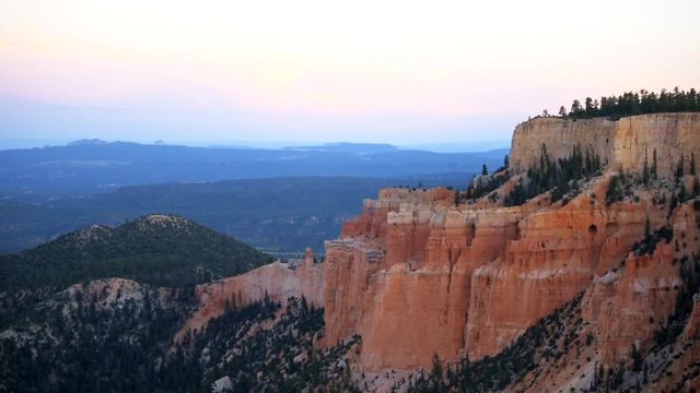 Paria view overlook of orange pink cliff rock hoodoos in Bryce Canyon National Park in Utah at dark sunset twilight and sunlight on formation