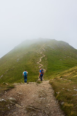 Fototapeta premium Climbers on a Scottish Munro Mountain in the mist 