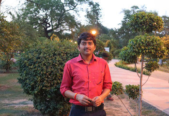 Young man feeling evening lighting in garden