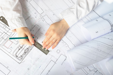 the architect works on architectural blueprints, construction plans in the office