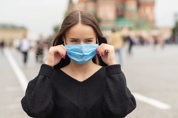 woman in a protective mask in the city during the coronavirus