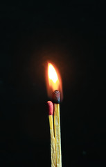 Couple of matches burning together with heat flame isolated on a black background.