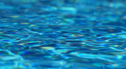 Abstract Beautiful blue pool water with reflections in many colors and ripples in the water 