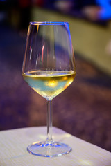 Glass of cold dry white wine served outdoor in cafe at night in Italy