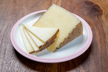 Cheese collection, pieces of different sheep hard manchego cheeses made in La Mancha, Spain served on white board