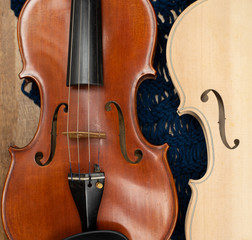 Closeup front of completed violin put beside raw violin,show detail of acoustic instrument