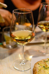 Glass of cold dry white wine served outdoor in cafe at night in Italy
