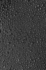 Water droplets on black background. Close-up photo of small water drops on black background.