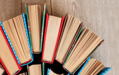 Books textbook in colorful covers on a wooden background. Back to school distance home education.Quarantine concept of stay home.