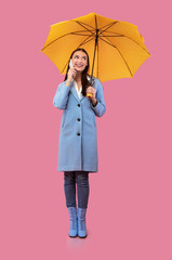 Portrait of smiling young girl holding yellow umbrella