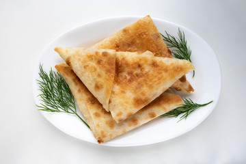 Dill pancakes with cream cheese filling on a white plate