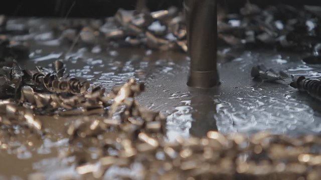 Industrial drill drilling an iron plate.