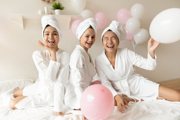 Well-groomed girls gather together celebrating bridal shower, wearing bath robe after spa beauty...