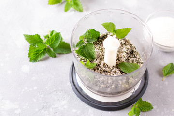 Homemade sugar scrub with chopped mint leaves in blender.