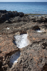 The puddles on the shore dry up, leaving only sea salt.