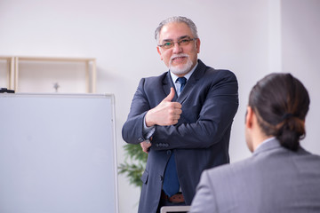 Naklejka premium Old and young businessmen in business meeting concept