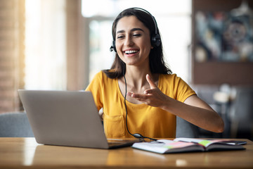 Positive young woman having videochat with friends