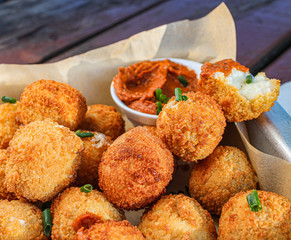 Cheese balls with tomato sauce. Fried snack starter meal. Party food