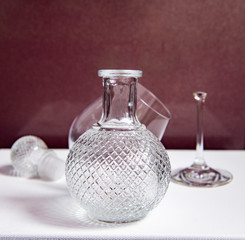 still life with a beautiful glass decanter and fruits on a dark background