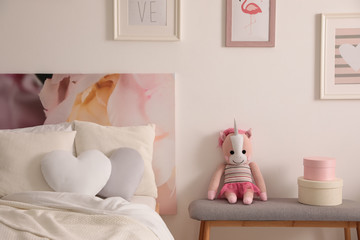 Modern teenager's room interior with comfortable bed and toy