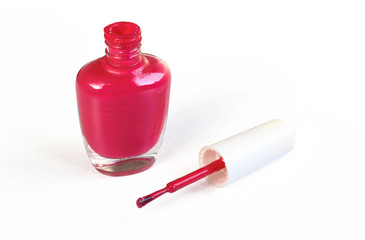 Red nail polish on white background. Opened glass bottle 