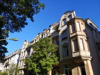 Häuserzeile mit schönem Altbau und Villa in Beige und Naturfarben im Sommer in einer Allee vor...